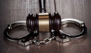the head of a gavel on top of a pair of handcuffs